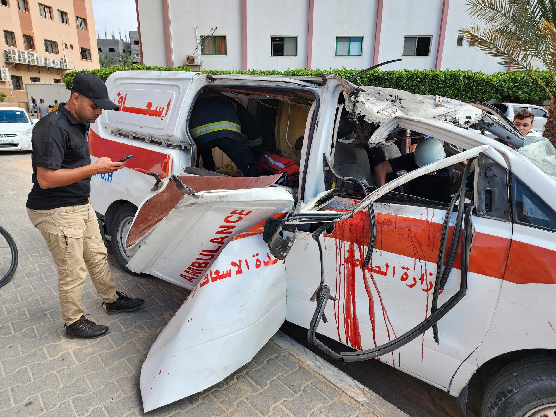 Läkare inspekterar en skadad ambulans efter ett israeliskt flyganfall mot Nassersjukhuset i Khan Younis i södra Gazaremsan.