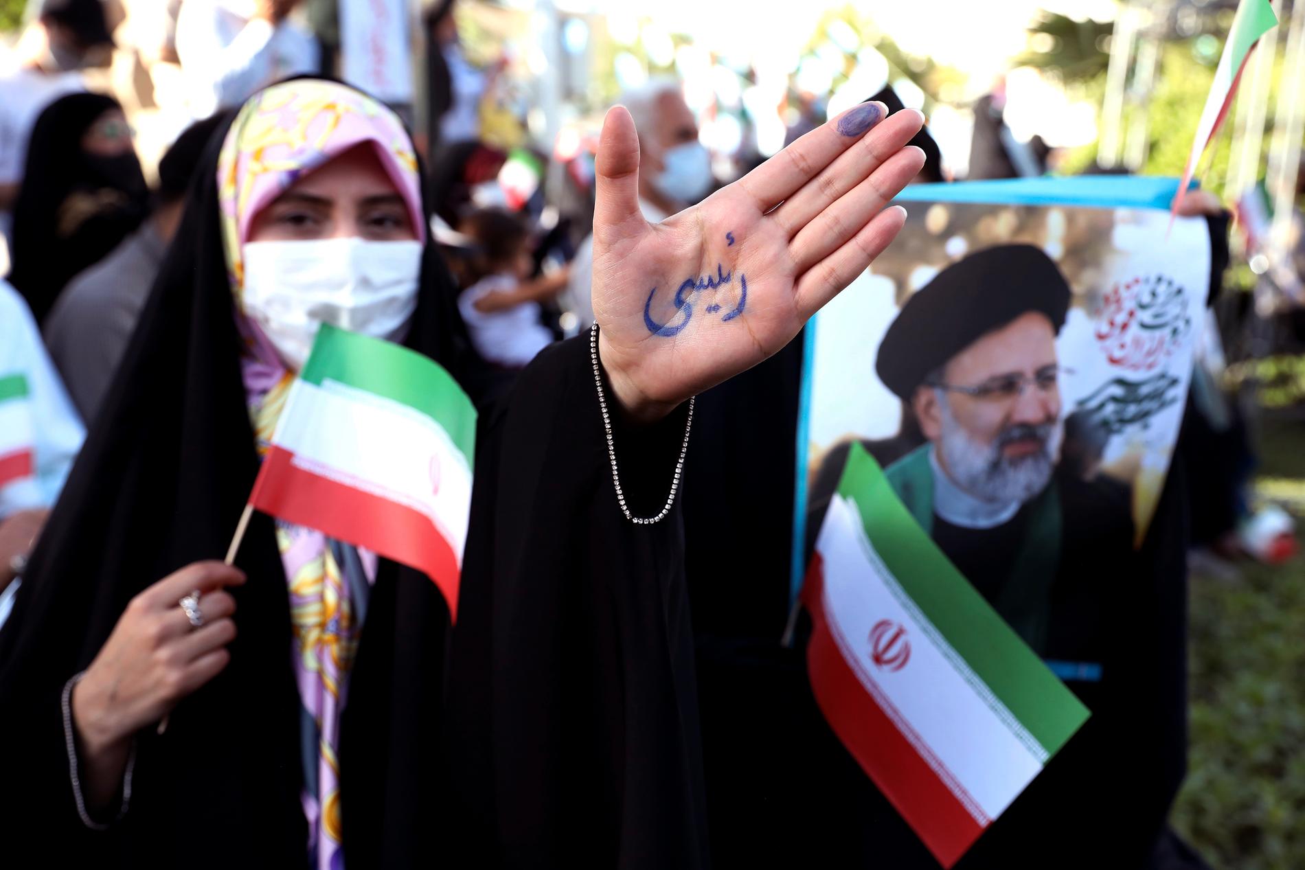 En anhängare till den konservative presidentkandidaten Ebrahim Raisi på ett valmöte i Teheran. På hennes hand står det just "Raisi".