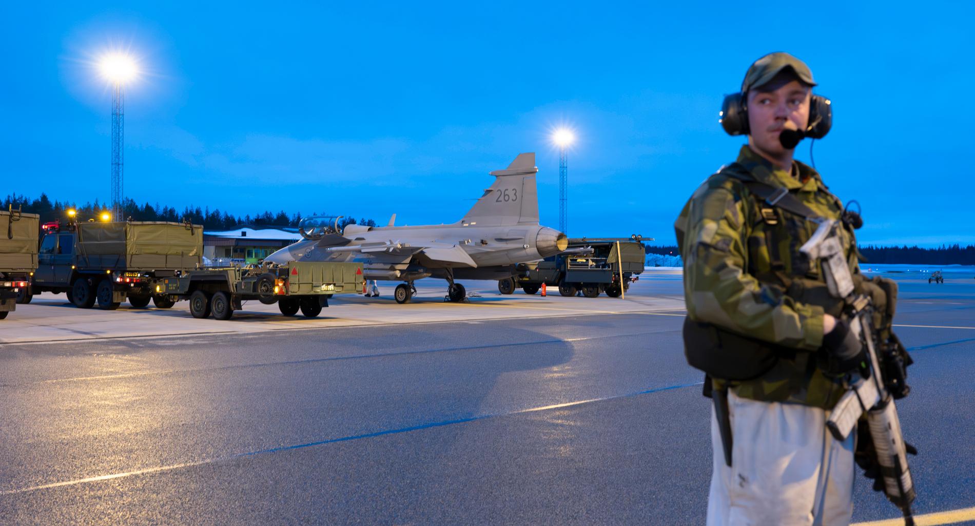 Svenska värnpliktiga från F21 gör en så kallad ”klargöring” på en JAS 39 Gripen C/D på Luleå-Kallax flygplats under militärövningen Nordic Response. Under övningen tränar de nordiska flygvapnen att kunna strida helt integrerat som om de vore ett enda flygvapen.