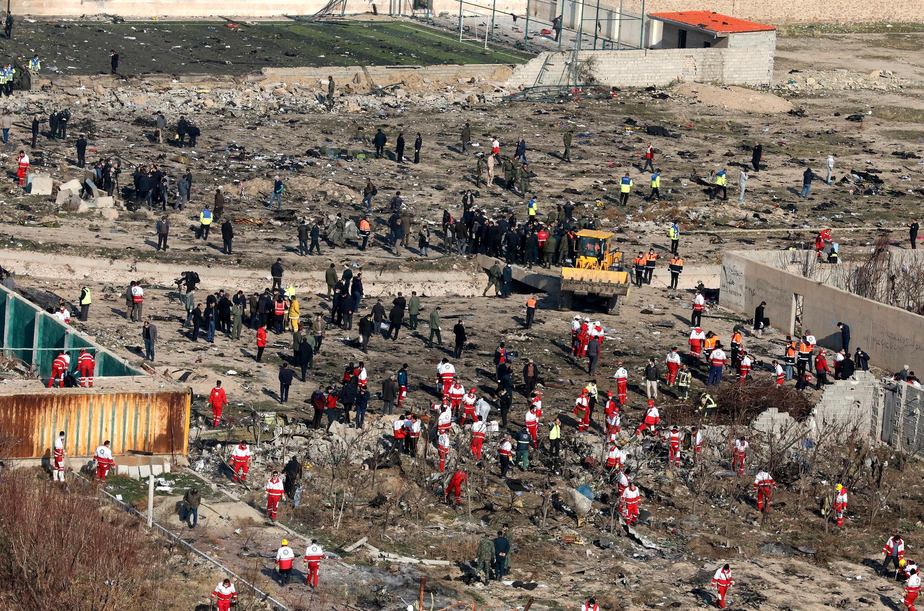Räddningsarbetare söker på platsen där det ukrainska planet kraschade i Shahedshahr i Iran. 