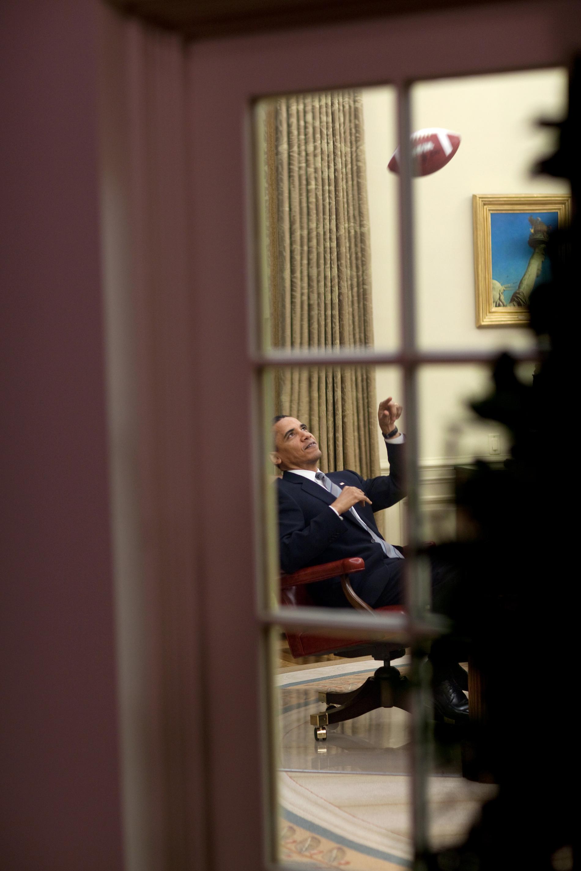 Obama leker med en amerikansk fotboll på sitt kontor.