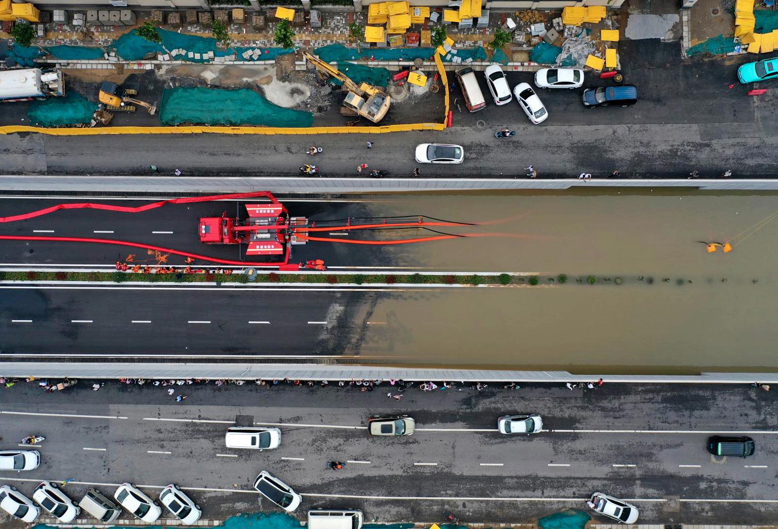 En flygbild över Zhengzhou, huvudstad i provinsen Henan, visar hur räddningstjänst pumpar vatten ur en översvämmad tunnel.