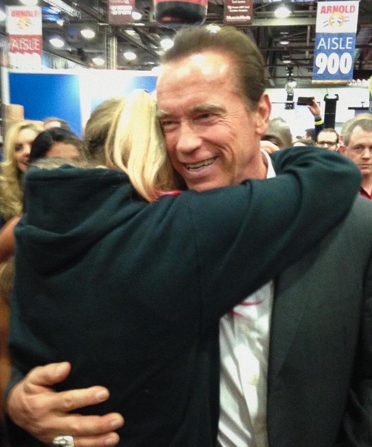 Maryana Naumova får en kram av Arnold Schwarzenegger.