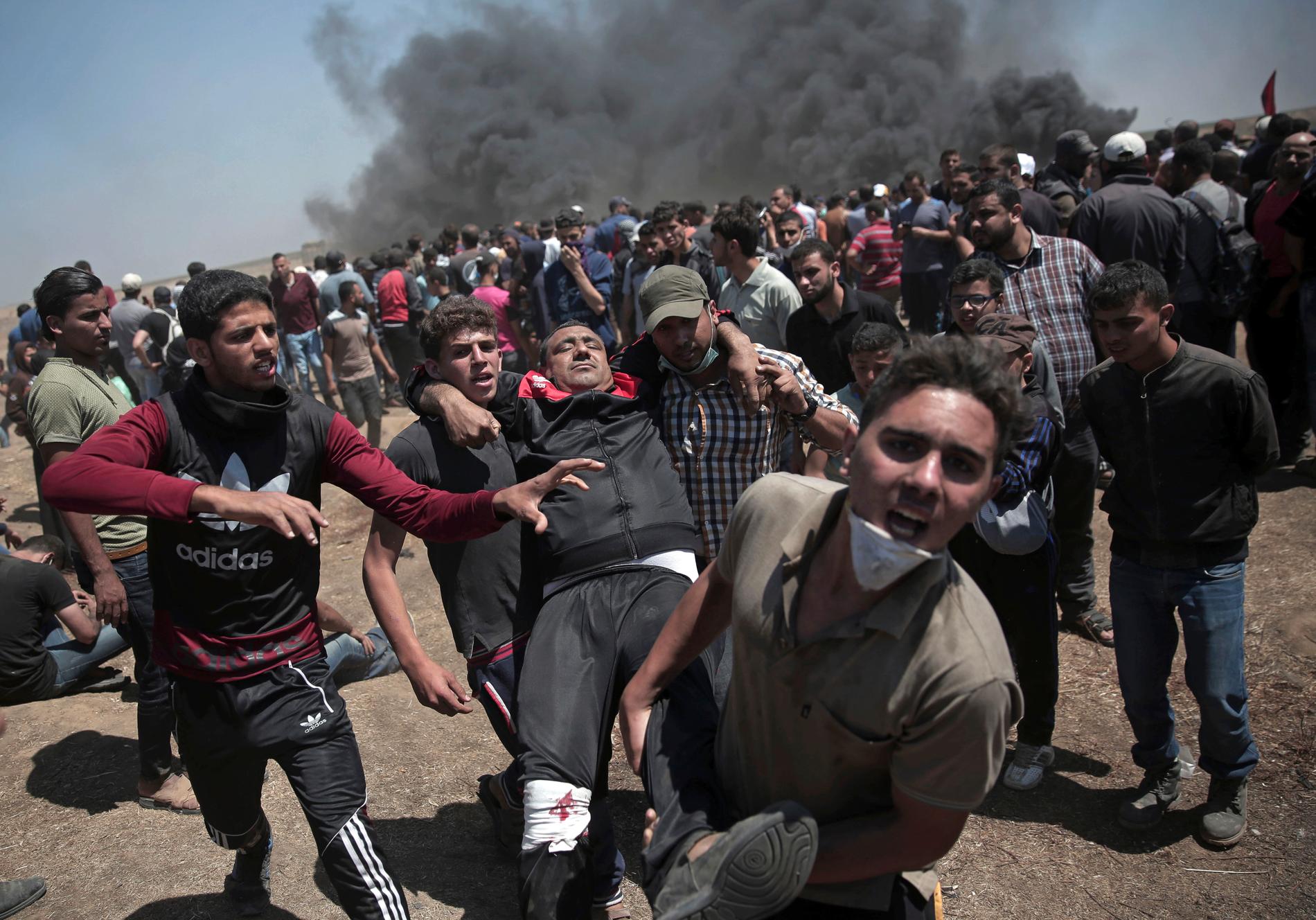 Palestinska demonstranter bär en skadad man som skjutits under protesterna.