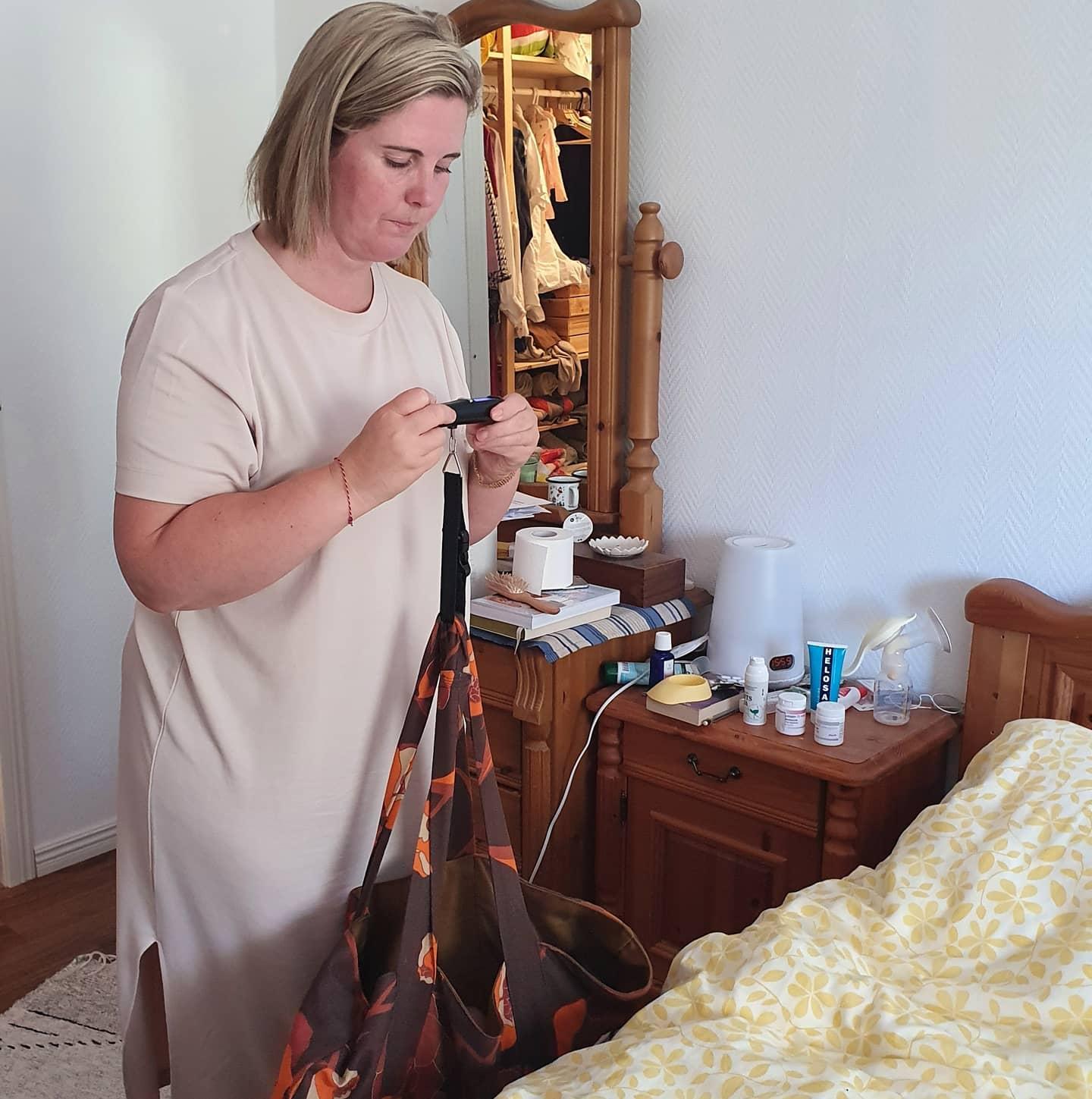 Cia Sandström väger ett nyfött barn i hemmiljö.