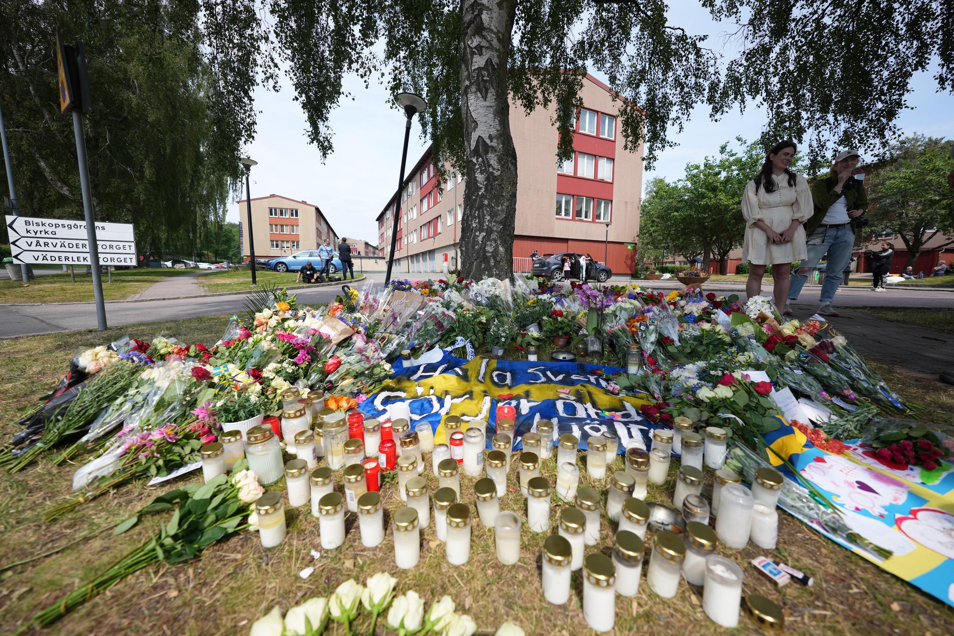 Blommor och ljus vid platsen i Biskopsgården i Göteborg där en polisman sköts till döds i slutet av juni. Arkivbild.