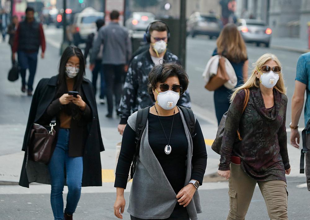 Människor utrustade med andningsmasker i ett rökfyllt San Fransisco.