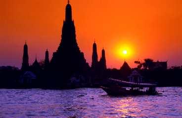 Wat Arun i solnedgång vid floden Chao Phraya kan få vem som helst att börja älska Bangkok.