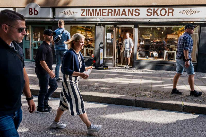 Magdalena Andersson passerar Zimmermans skor i Gävle samtidigt som butiksägaren Thorbjörn Windahl tittar ut.