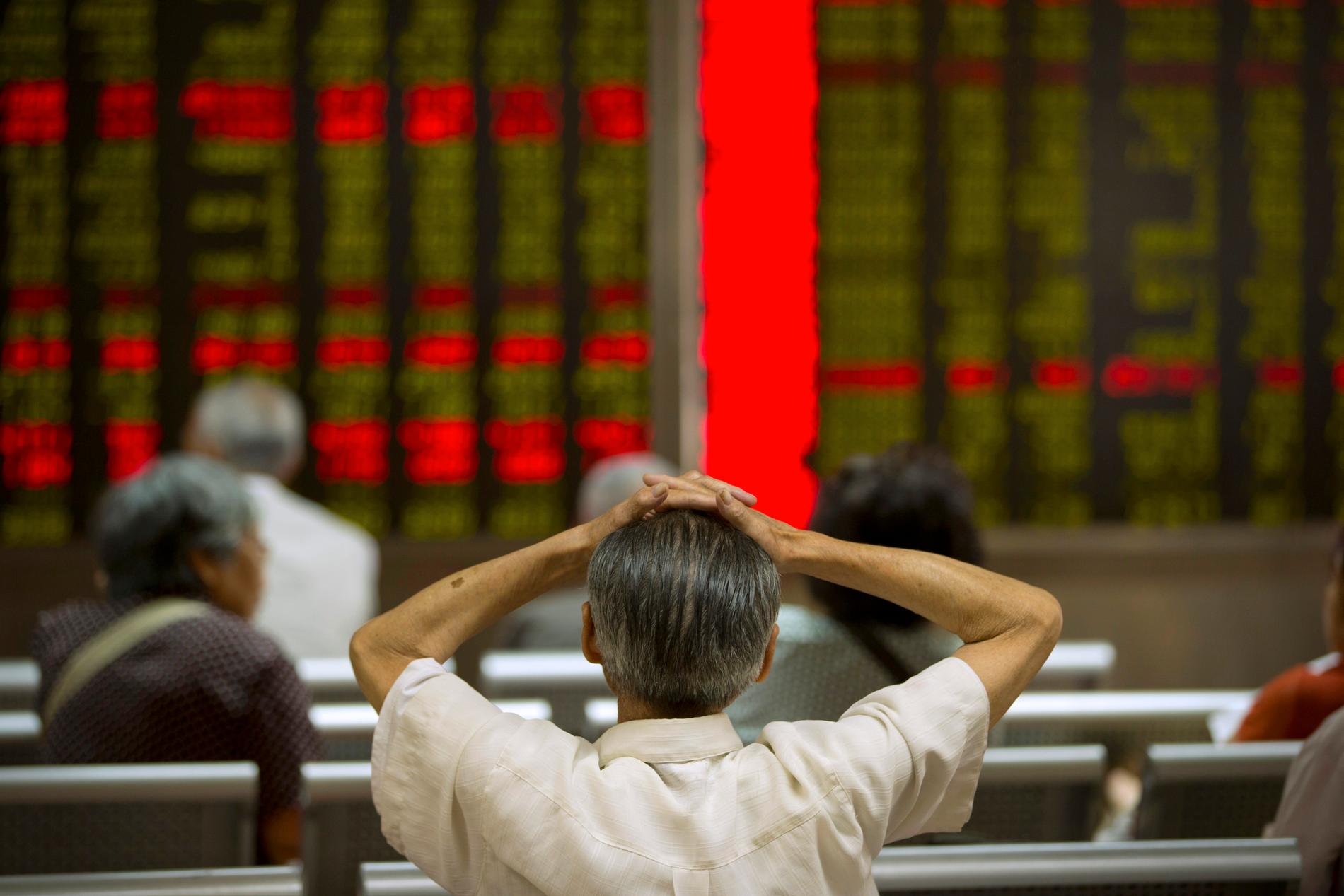 En kinesisk börsmäklare följer kursen.