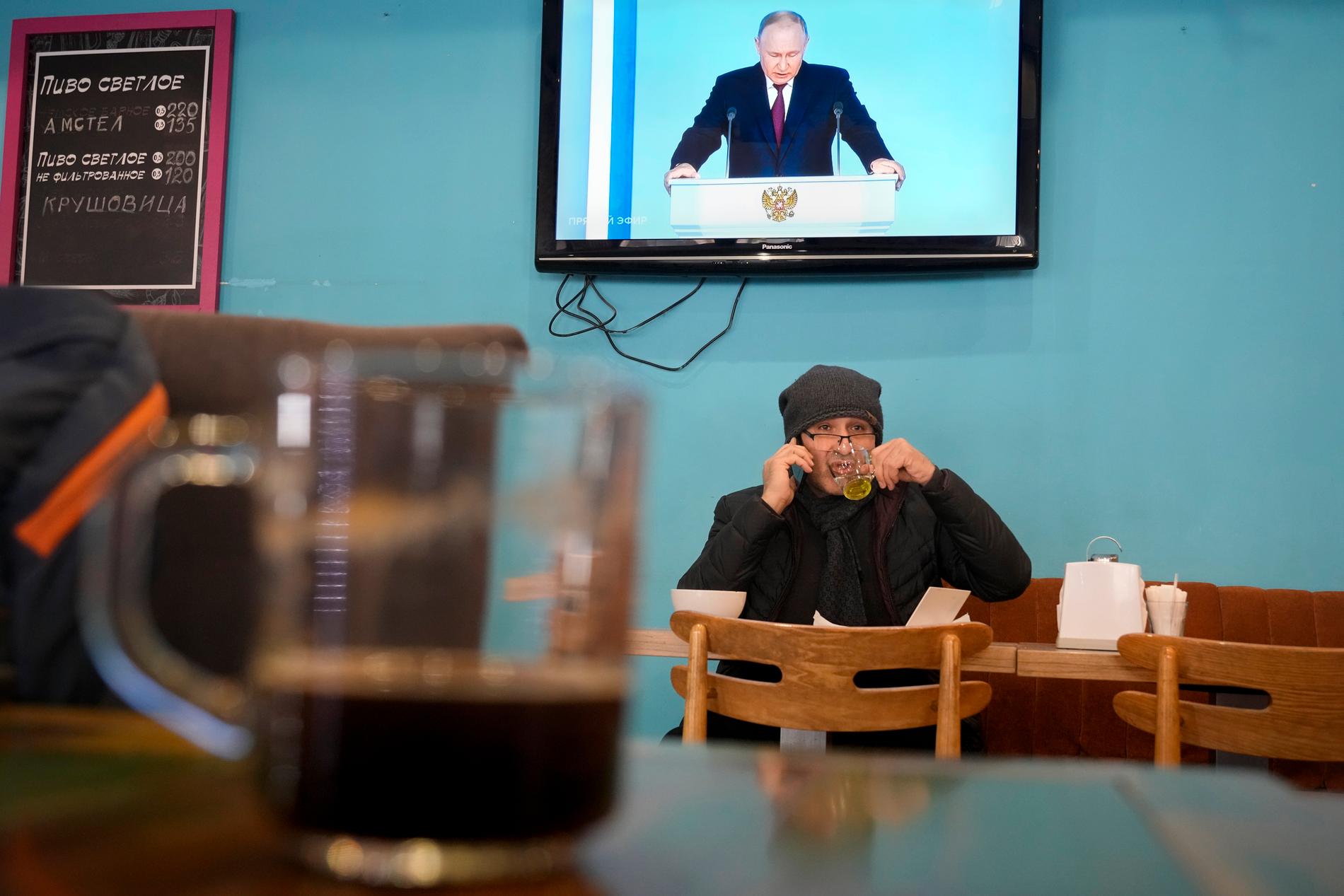 En man dricker te på ett kafé i S:t Petersburg under Vladimir Putins årliga tal till parlamentet.