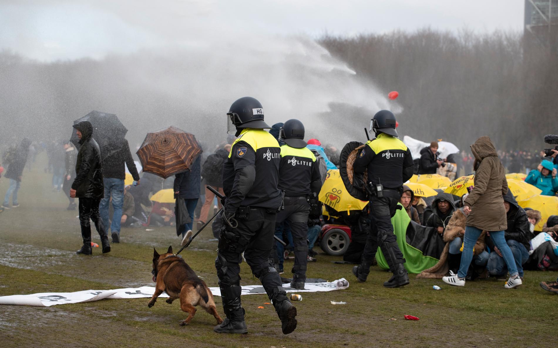 Vattenkanoner och hundar användes av polisen för att bryta upp en protest mot coronarestriktionerna i Nederländerna.