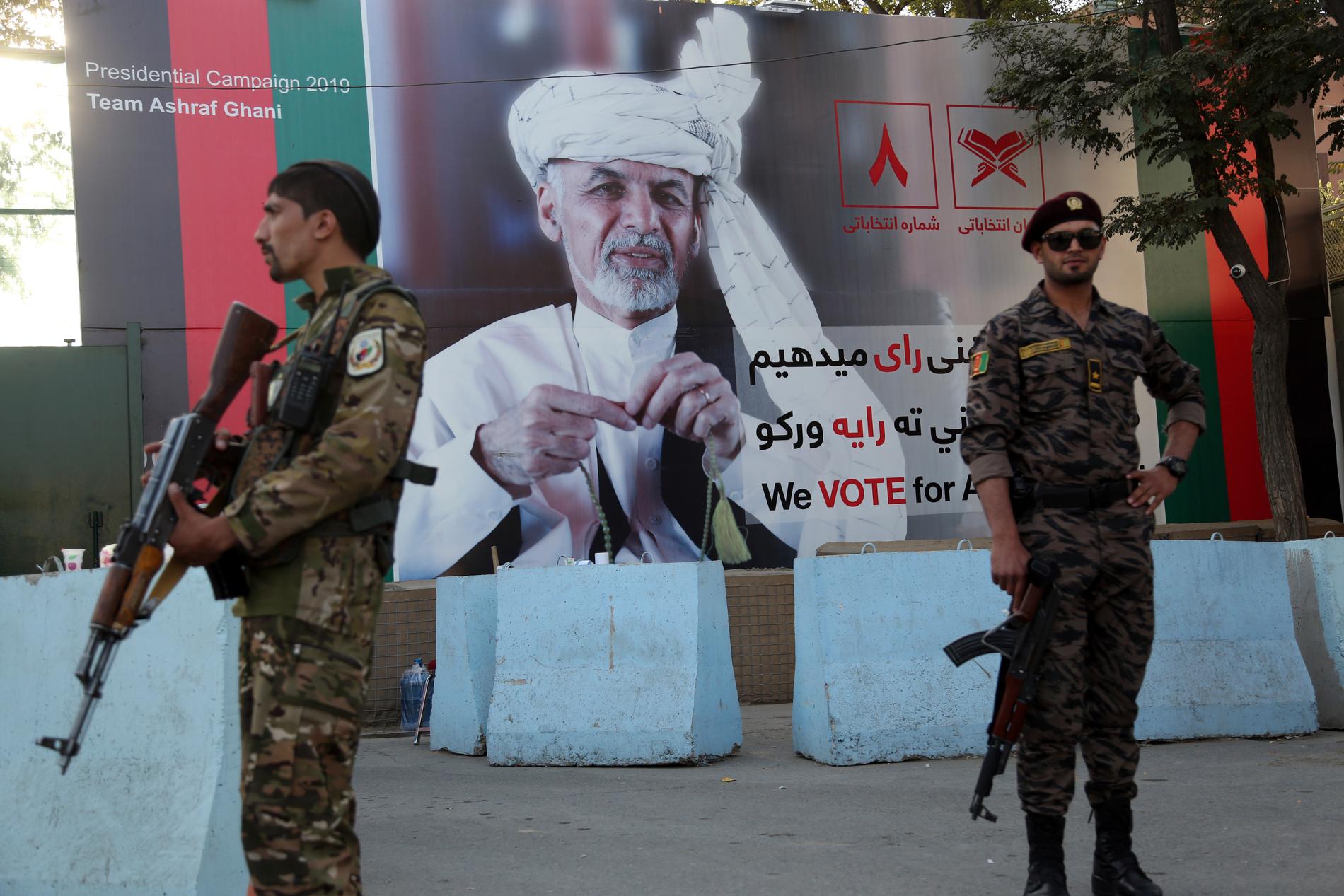 Afghanska regeringssoldater på vakt framför valreklam för president Ashraf Ghani inför presidentvalet i september 2019.