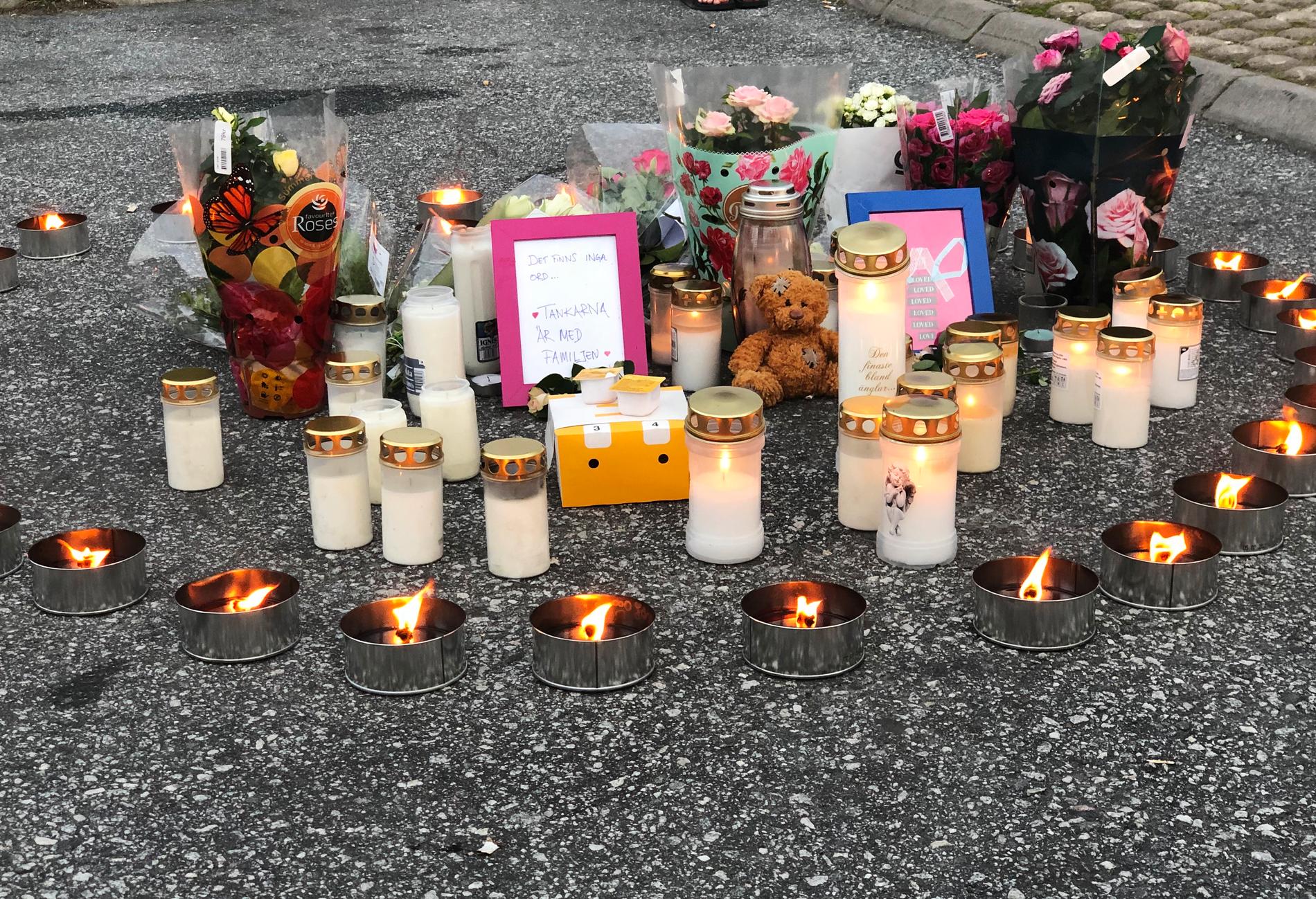 Flera personer har lagt blommor och ljus på platsen där den 12-åriga flickan sköts.