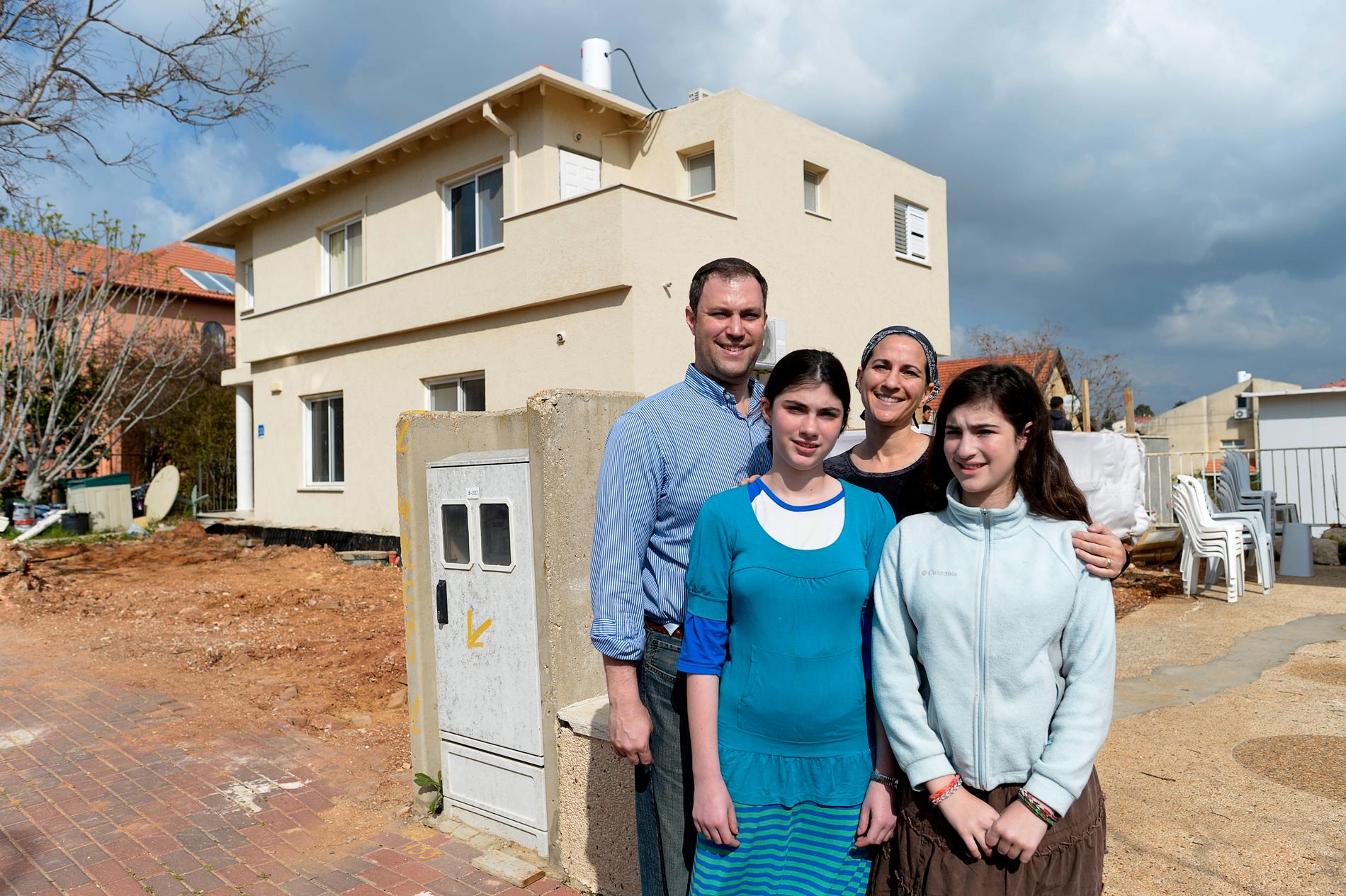 Israeliske bosättaren Elie Pieprz  med familj framför huset de köpt och håller på att reparera.