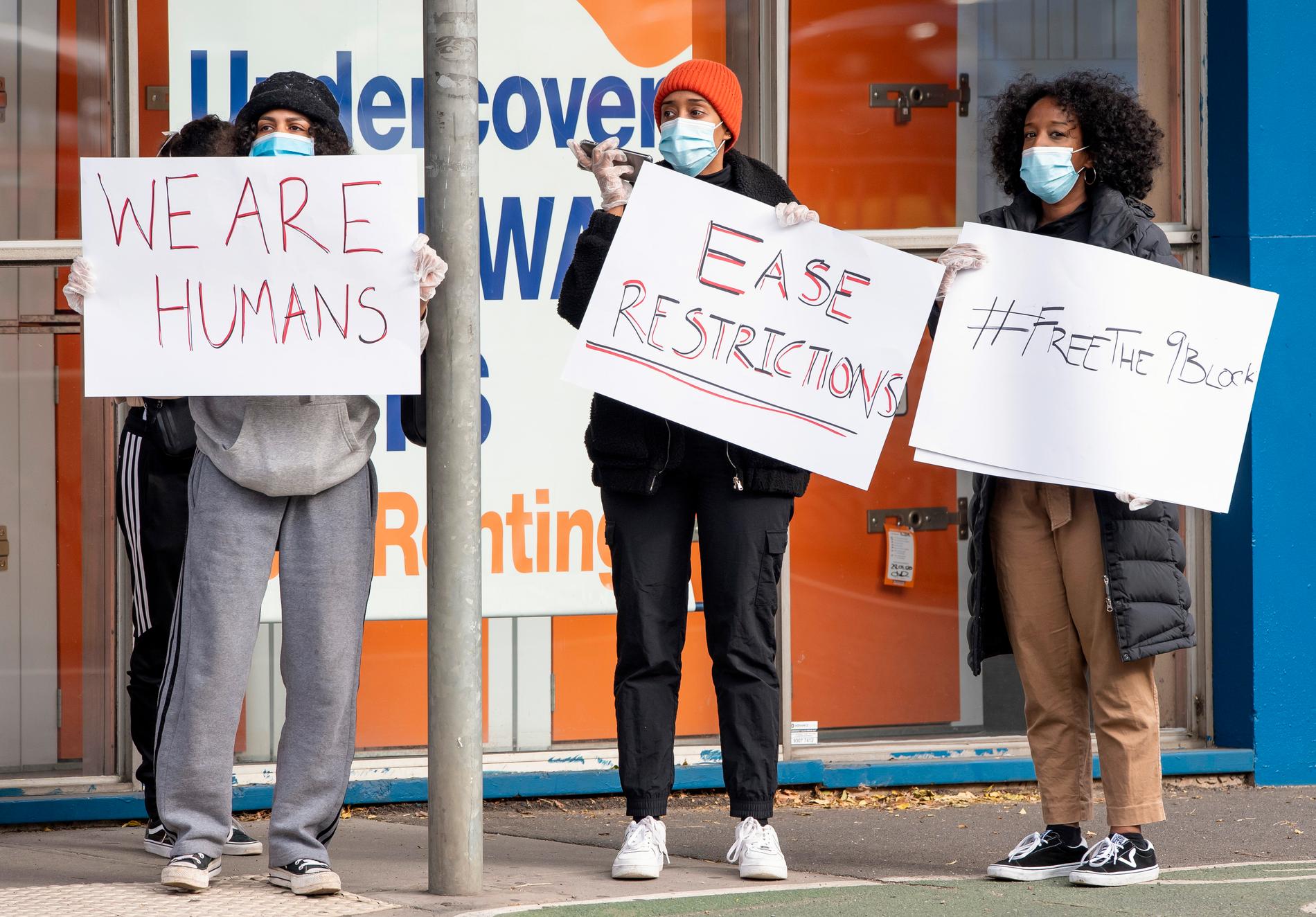 Kvinnor protesterar mot de nya virusrestriktionerna vid ett drabbat bostadskomplex i Melbourne den 6 juli.