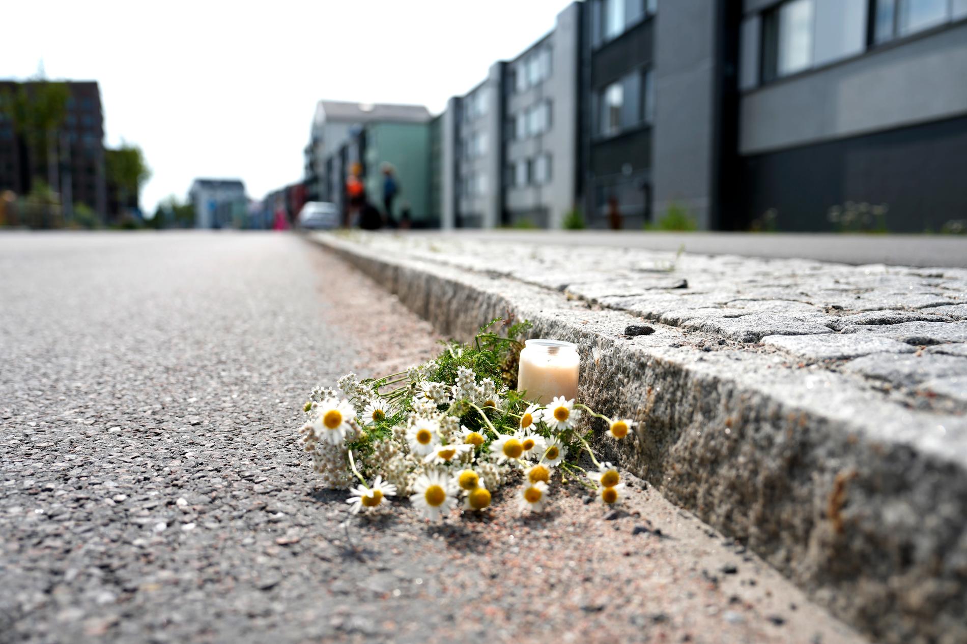 En blomma och ett ljus på platsen där Nadja Blom dog.