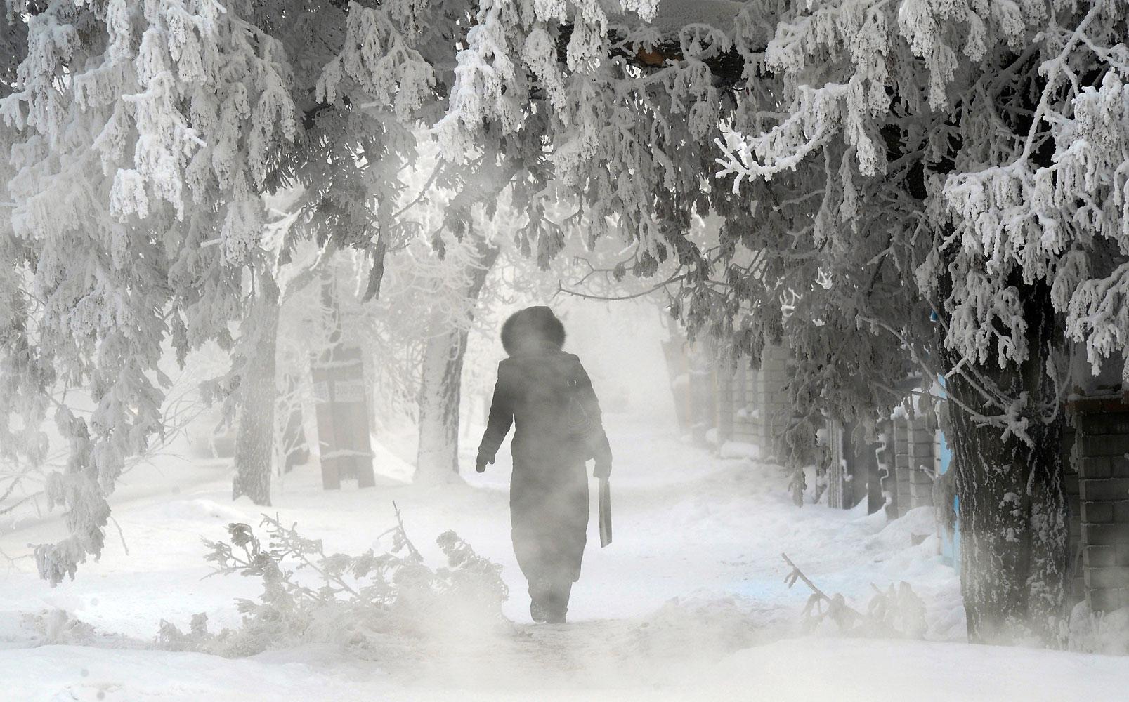 En kvinna på en snöig väg i poldovar, Kazakstan.
