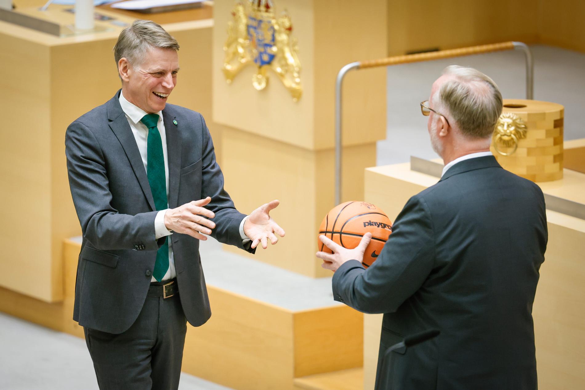 Miljöpartiets språkrör Per Bolund tackas av och får present (en basketboll) av Liberalernas partiledare Johan Pehrson.