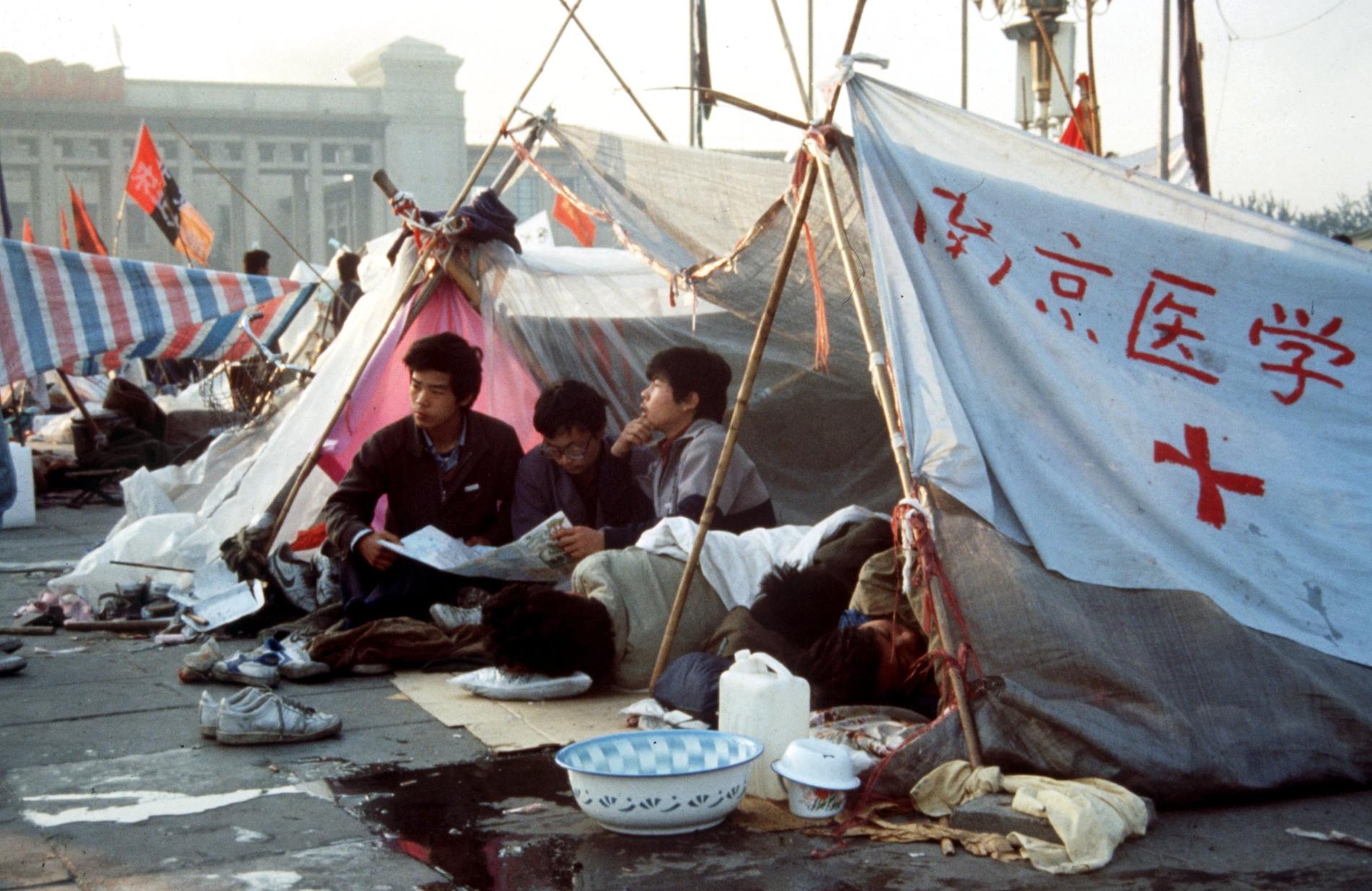 Ungdomar med flaggor och banderoller demonstrerar på Himmelska fridens torg i Peking 1989. De kinesiska myndigheterna kväste demokratirörelsen med sanslöst övervåld. Arkivbild.