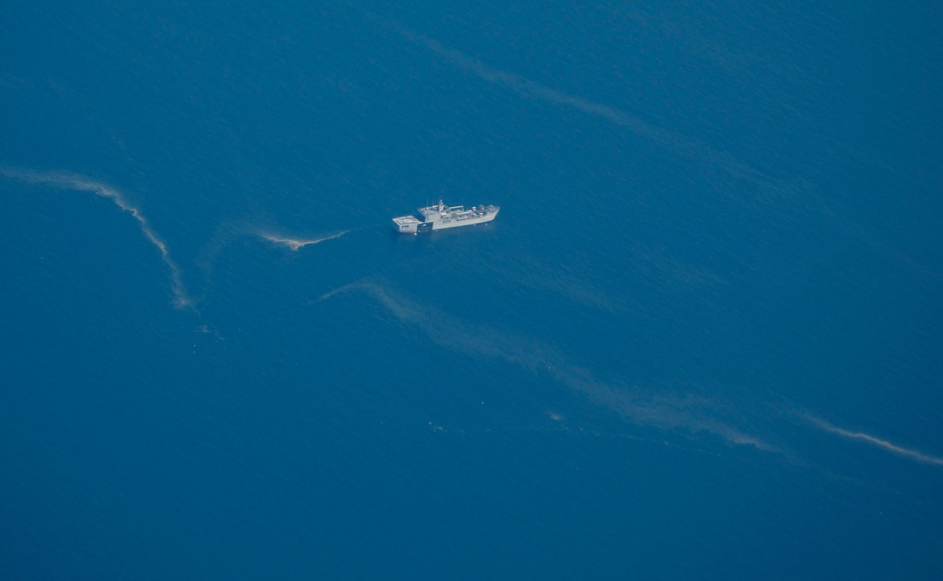 En båt från indonesiska flottan söker kring oljespill som tros komma från ubåten.