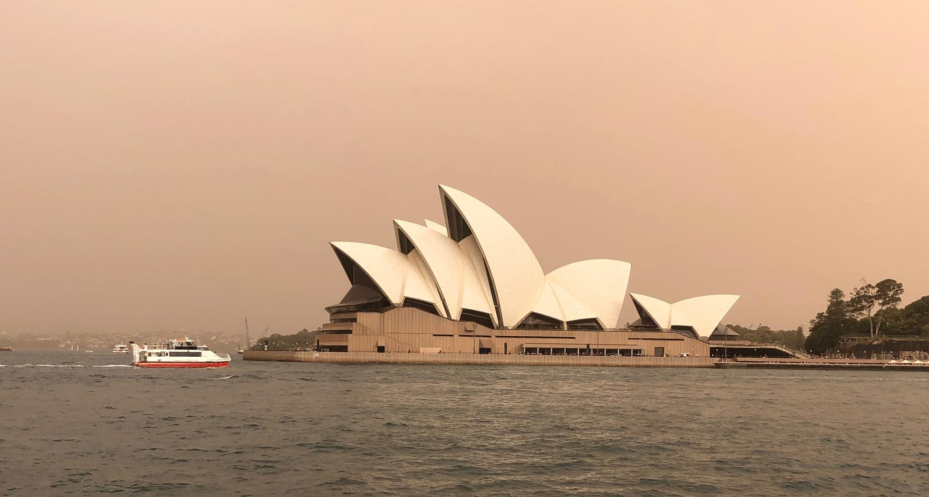 Brandrök över operan i Sydney i samband med bränder i början av november i fjol. Arkivbild.