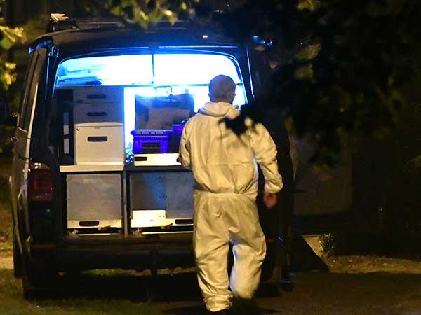Kriminaltekniker undersöker bostaden i Trelleborg där två personer hittades döda.