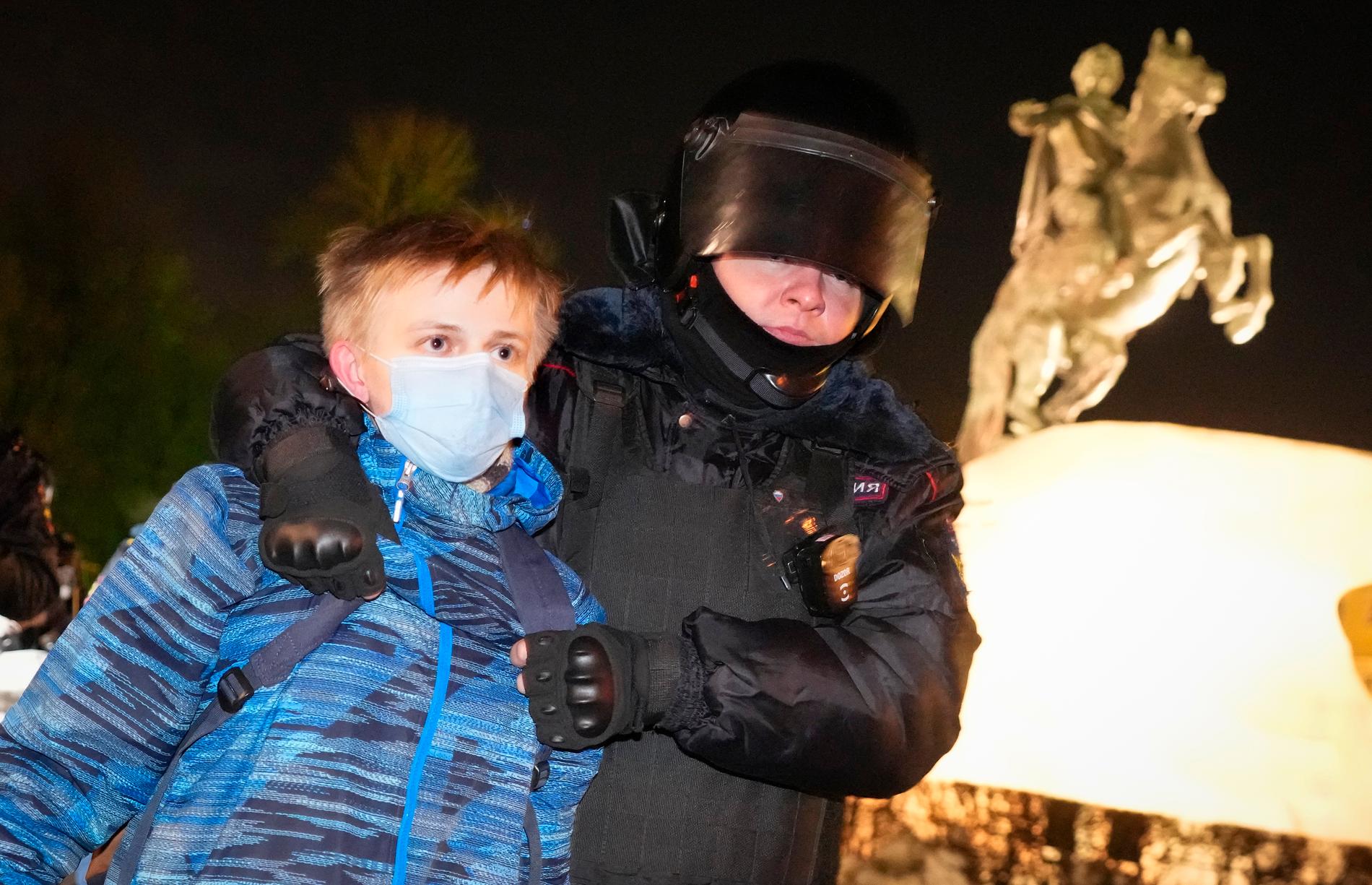 En ung demonstrant grips av polis i samband med en demonstration mot kriget i St Petersburg.