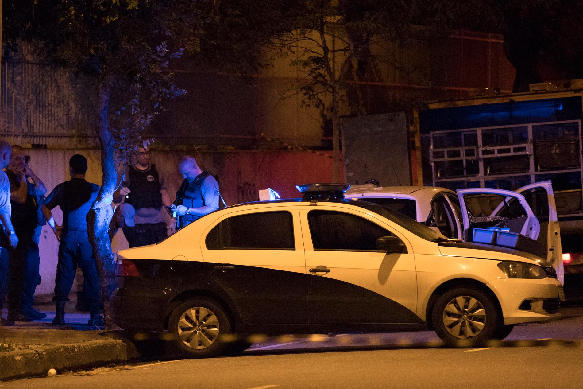 Poliser undersöker brottsplatsen och bilen där Marielle Franco och hennes chaufför mördades i Rio de Janeiro den 14 mars 2018.
