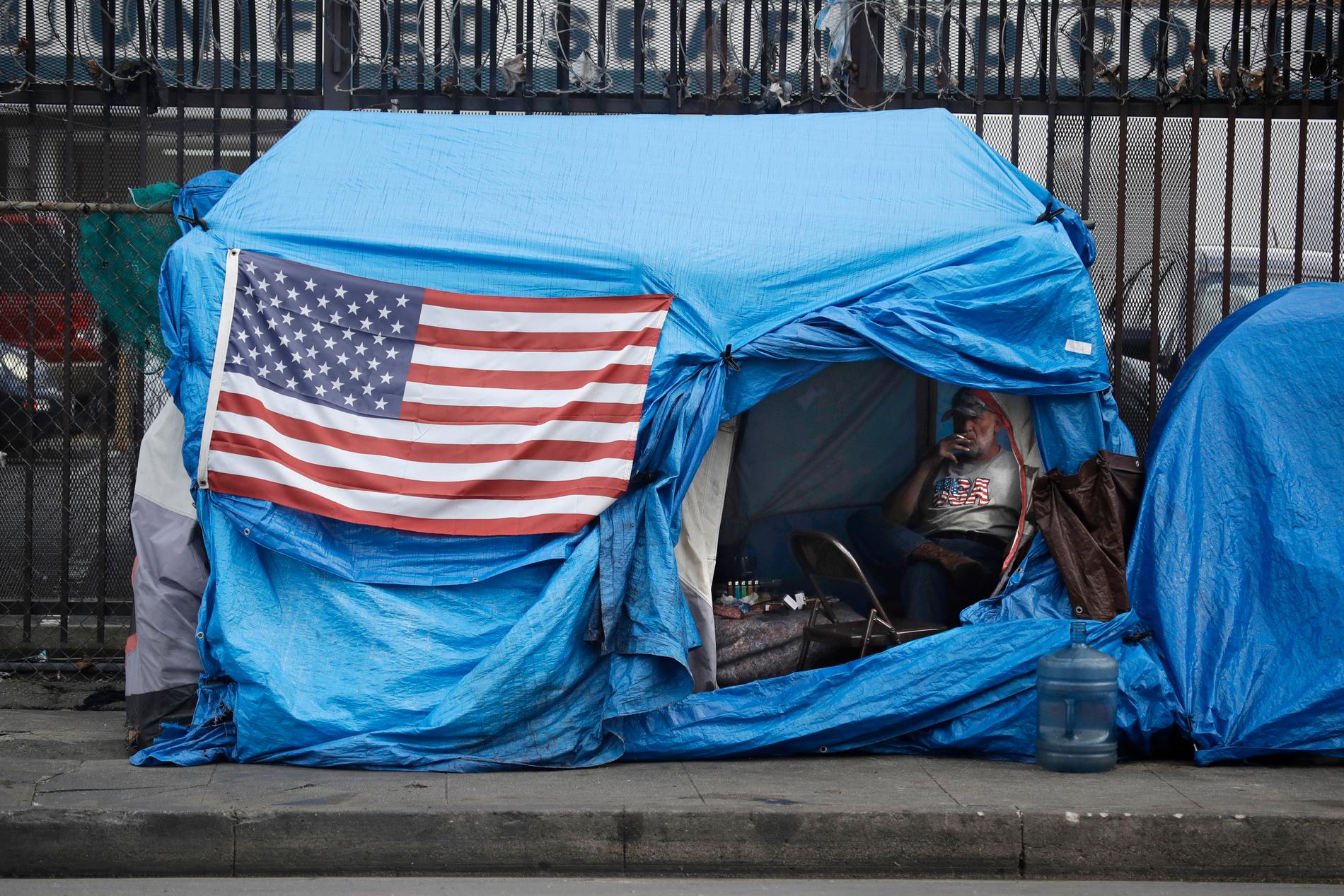 LOS ANGELES, USA En hemlös man inne i sitt tält på ”skid row”, Los Angeles, på fredagen. Myndigheter i Kalifornien har beordrat dess 40 miljoner invånare att stanna hemma tills vidare.