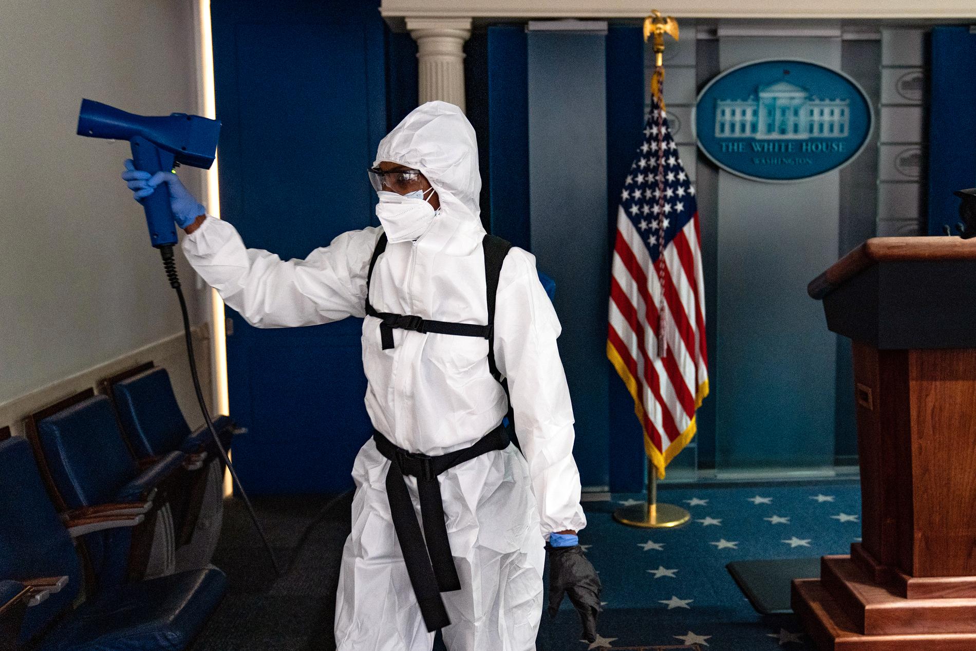 En städare i Vita huset sprutar desinfektionsmedel i de till synes öde lokalerna.