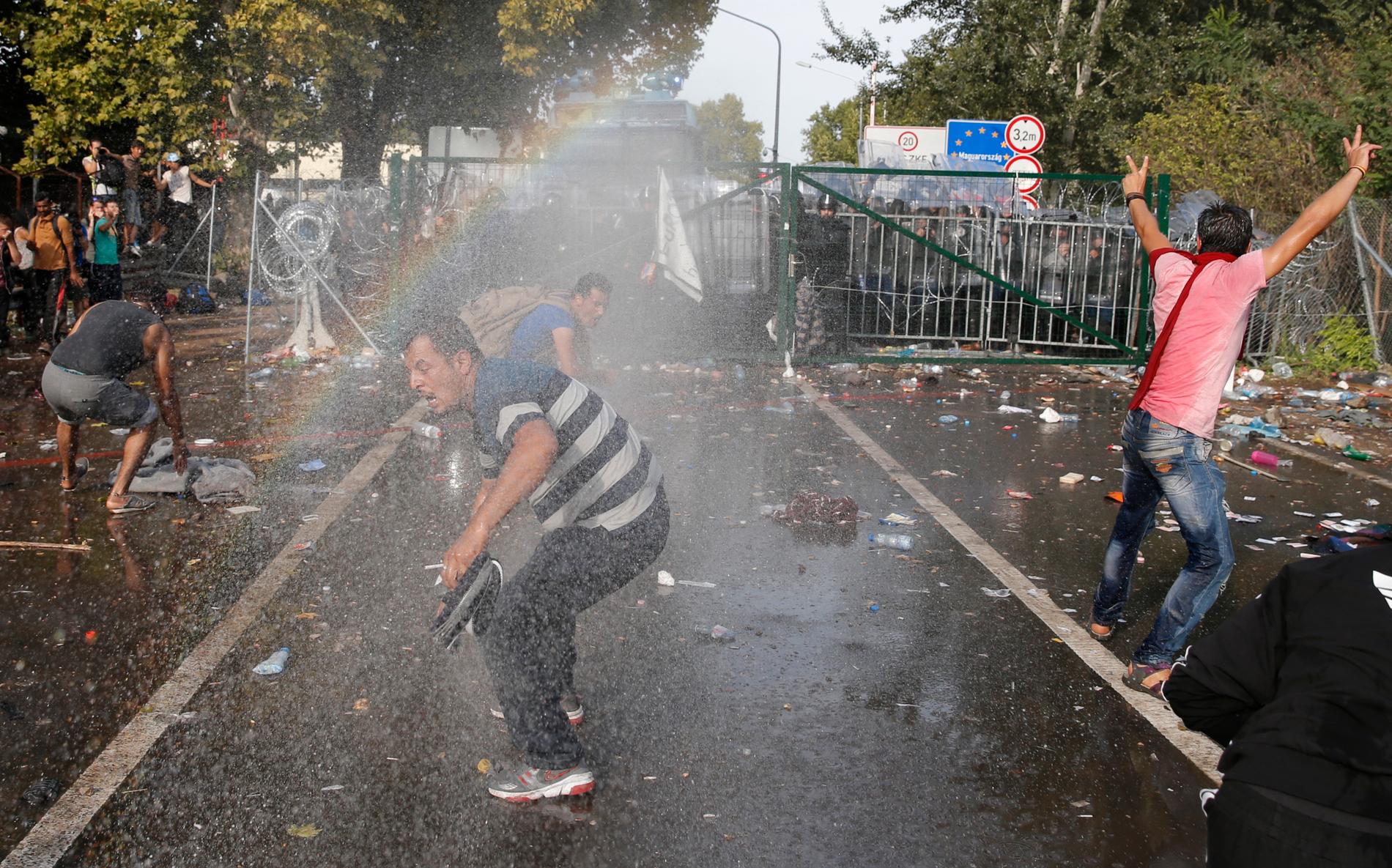 Migranter på den serbiska sidan av gränsen efter att polisen använt tårgas mot flyktingarna.