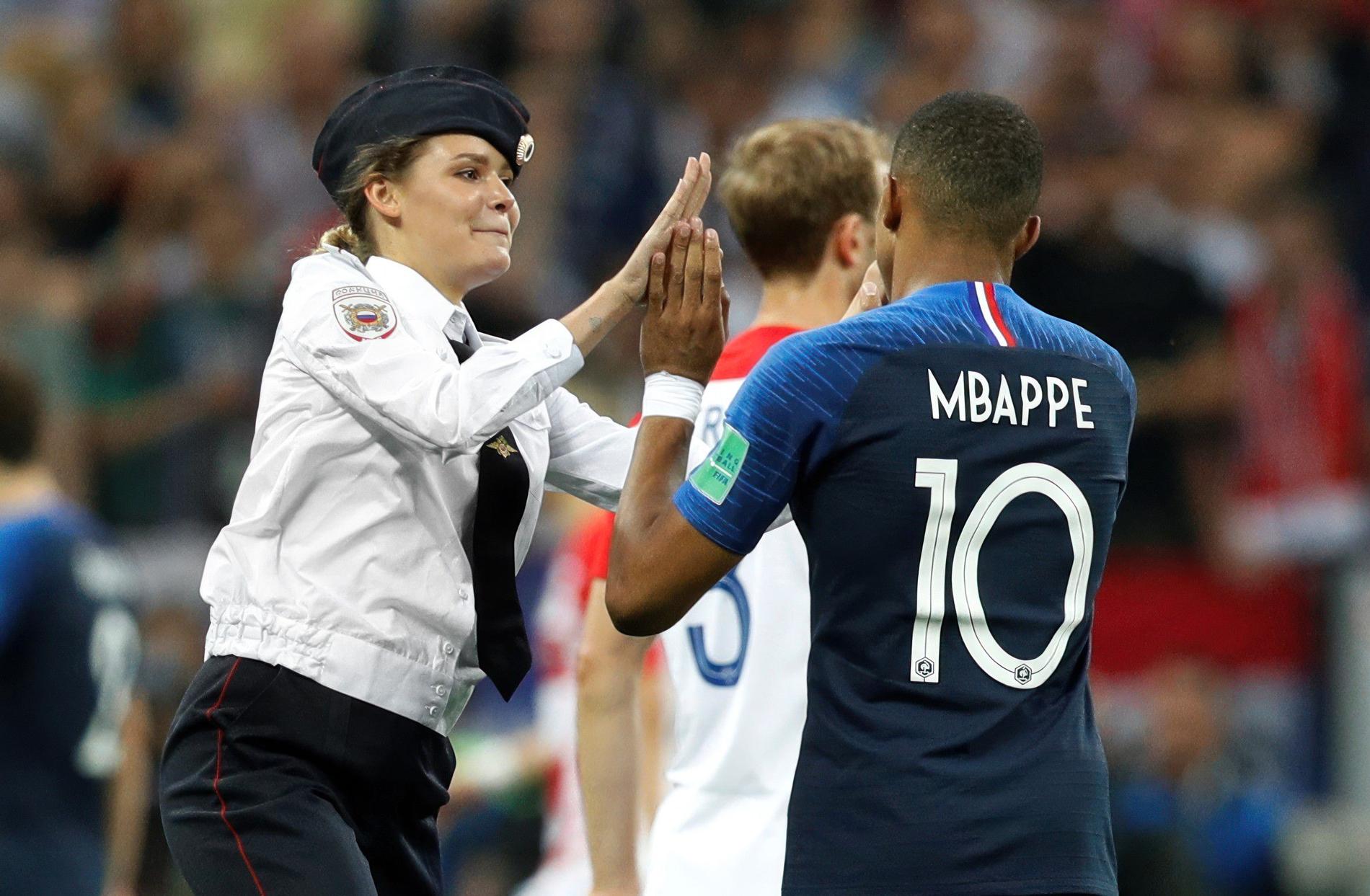 Frankrikes Kylian Mbappé high fivar med en Pussy Riot-medlem under fotbolls-VM-finalen i Moskva 2018.