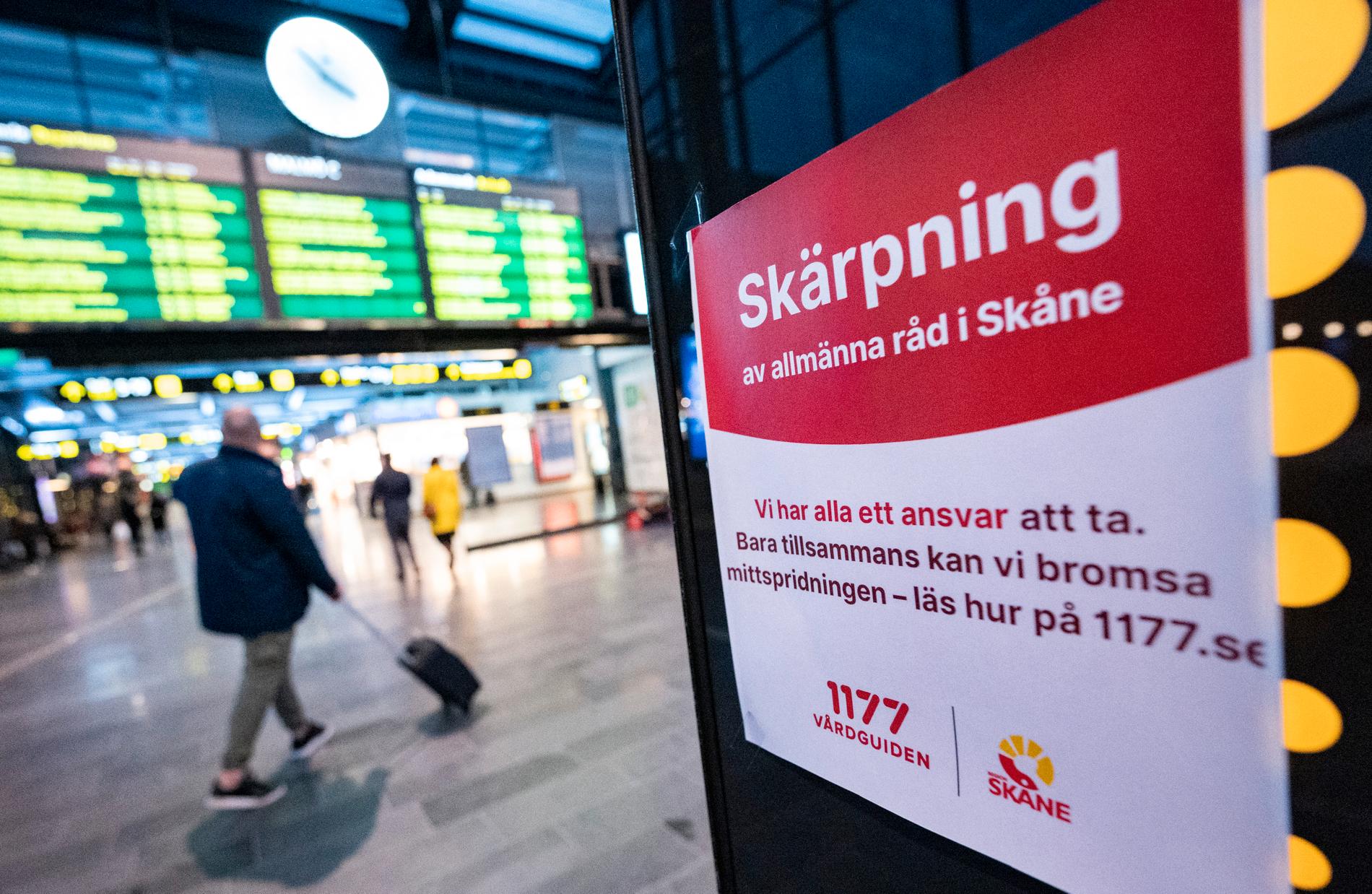Skärpning av allmänna råd i Skåne – resenärer passerar förbi information på Malmö C gällande coronasmittan i december 2020. 