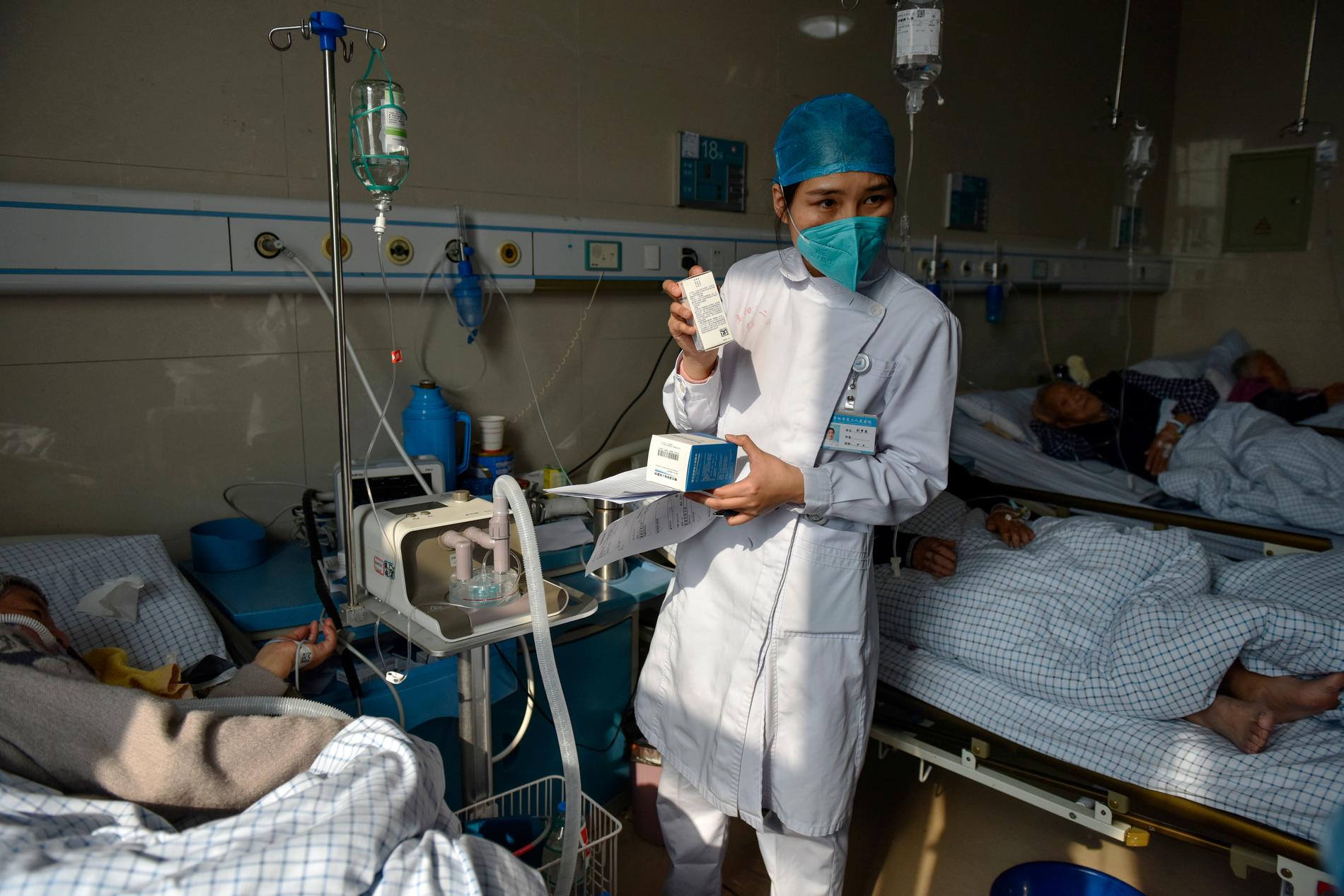 En sjuksköterska medicinerar en äldre patient på sjukhuset i Fuyang i provinsen Anhui, östra Kina.