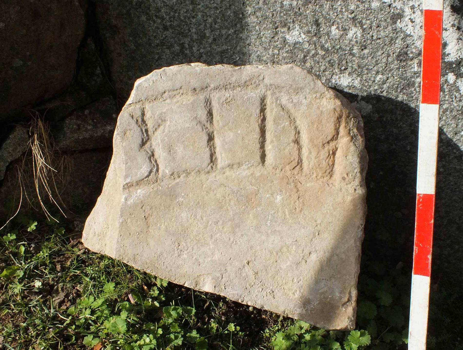 Ett av fynden är ett runstensfragment av kalksten som låg i en mur.