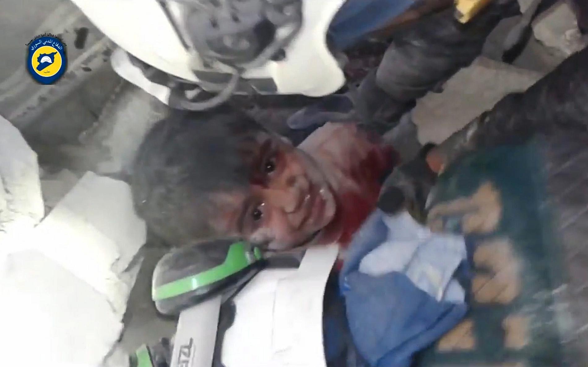 Ett barn grävs ut ur rasmassorna efter en av de senaste dagarnas bombningar i Aleppo. Bilden har gjorts tillgänglig av den syriska hjälporganisationen "White Helmets".