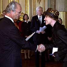 Marie Fredriksson tar emot sin medalj ur kung Carl Gustafs hand.