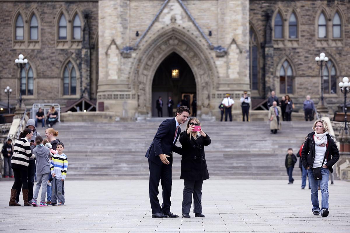 Justin Trudeau ställer upp på en selfie utanför parlamentet i Ottawa. Under tisdagen har varit ute på stan och träffat kanadensare. De flesta ville gärna hälsa eller ta en bild på sin nye premiärminister.