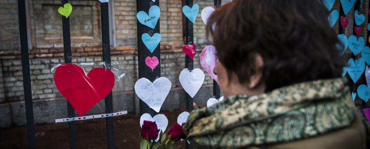 Blommor och pappershjärtan sattes upp på grindarna till synagogan i Göteborg efter brandattacken i december 2017. 