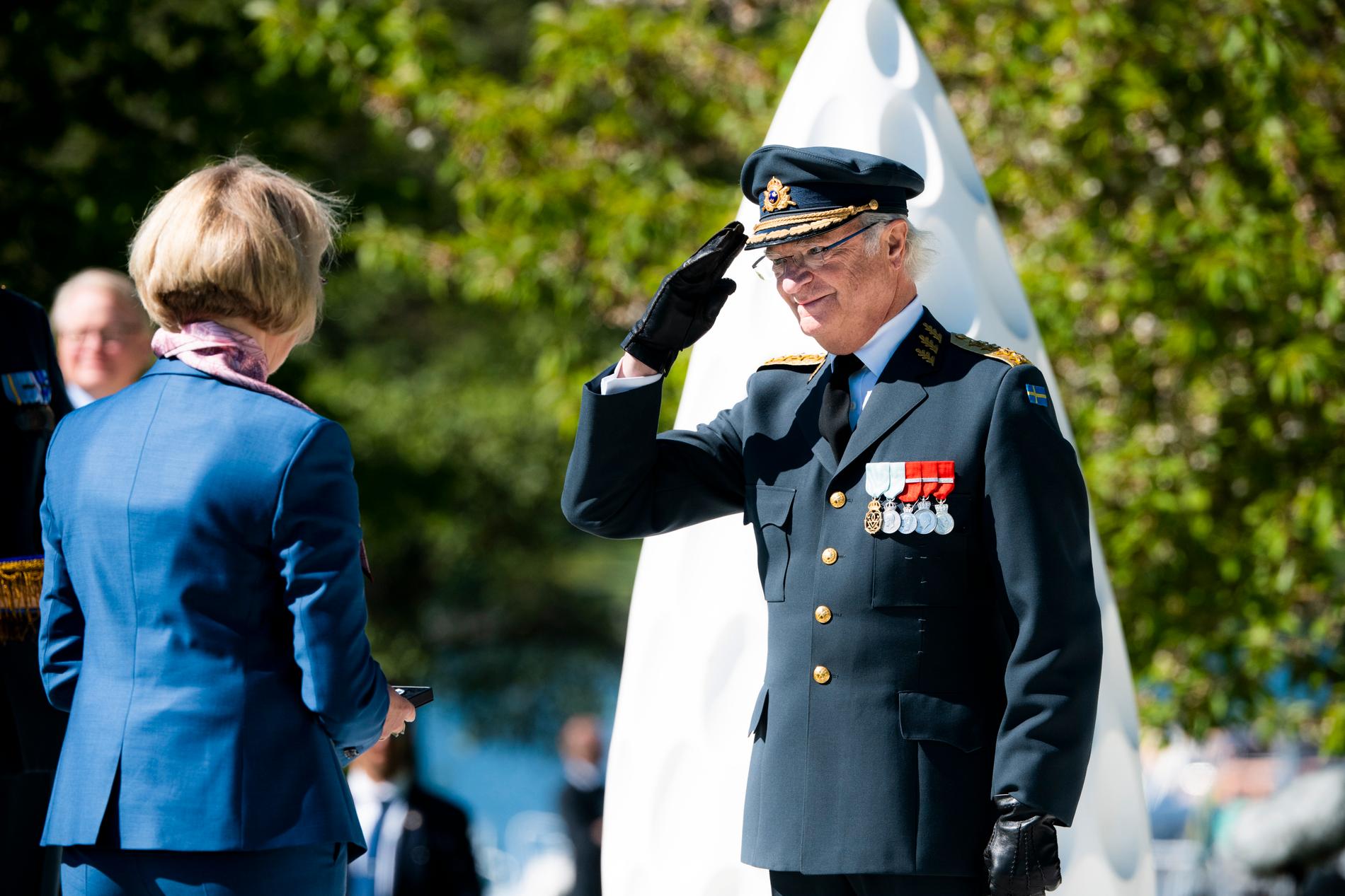 Kung Carl Gustaf delar ut medalj till Maritha Küller under lördagens ceremoni vid veteranmonumentet Restare på Gärdet.