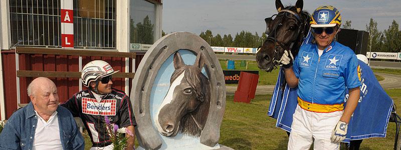 Stig Lindmark, kusken Ulf Ohlsson och vinnaren av Steggbests Minne, Hallsta Lotus. Tränaren Jan-Olov Persson håller i hästen.