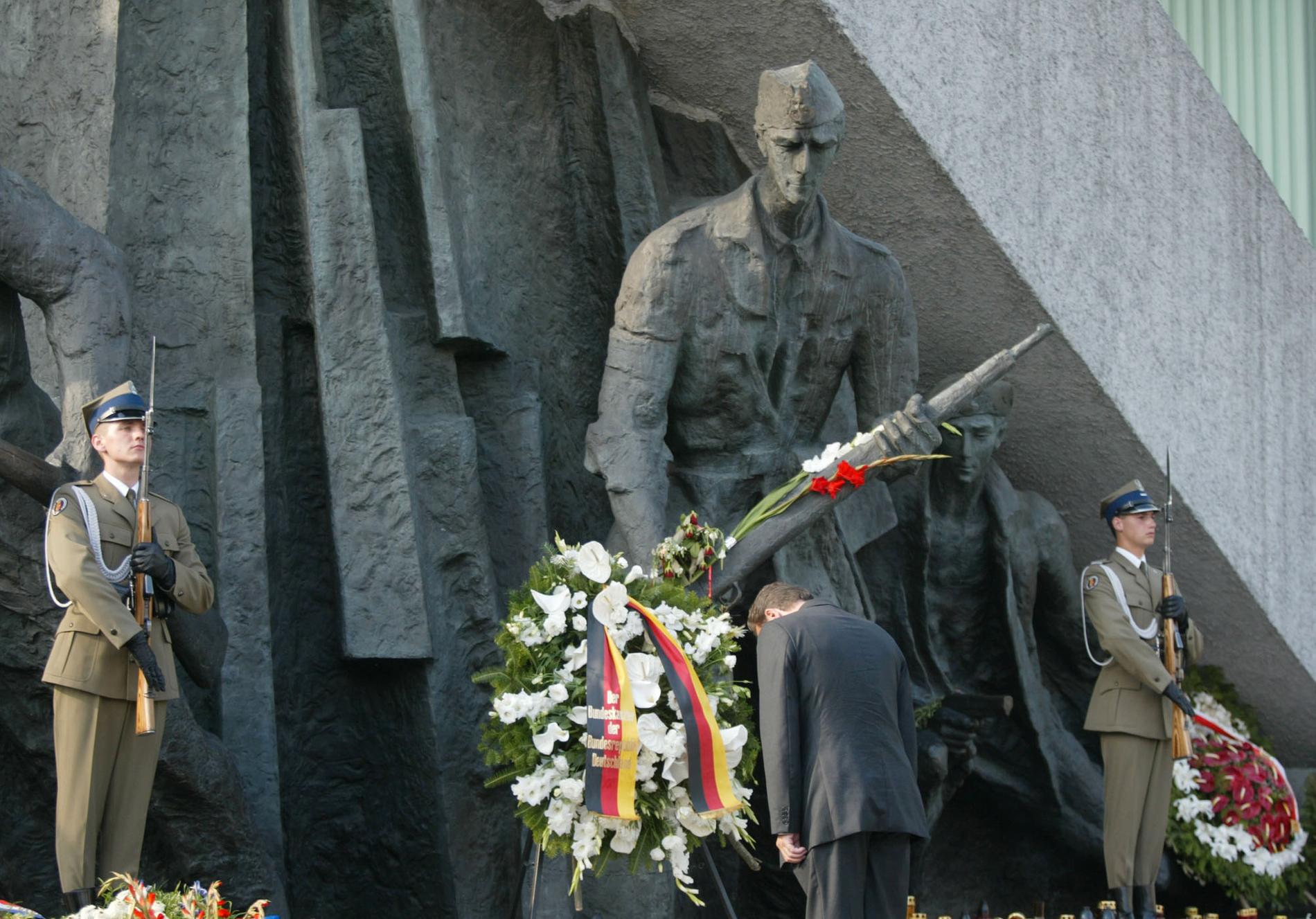 Tysklands förbundskansler Gerhard Schröder bugar sig inför ett minnesmonument över Warszawaupproret, från 60-årsminnet.