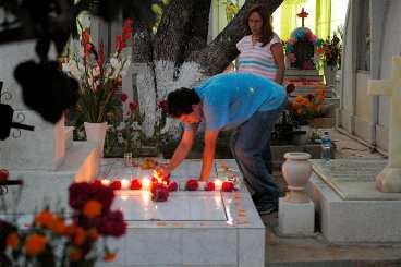 Till kyrkogården San Miguel i Oaxaca kommer familjemedlemmar för att dekorera anhörigas gravar med blommor och ljus.