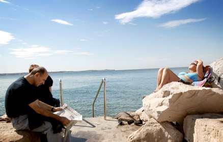 Att solbada på kajen i Piran är populärt.