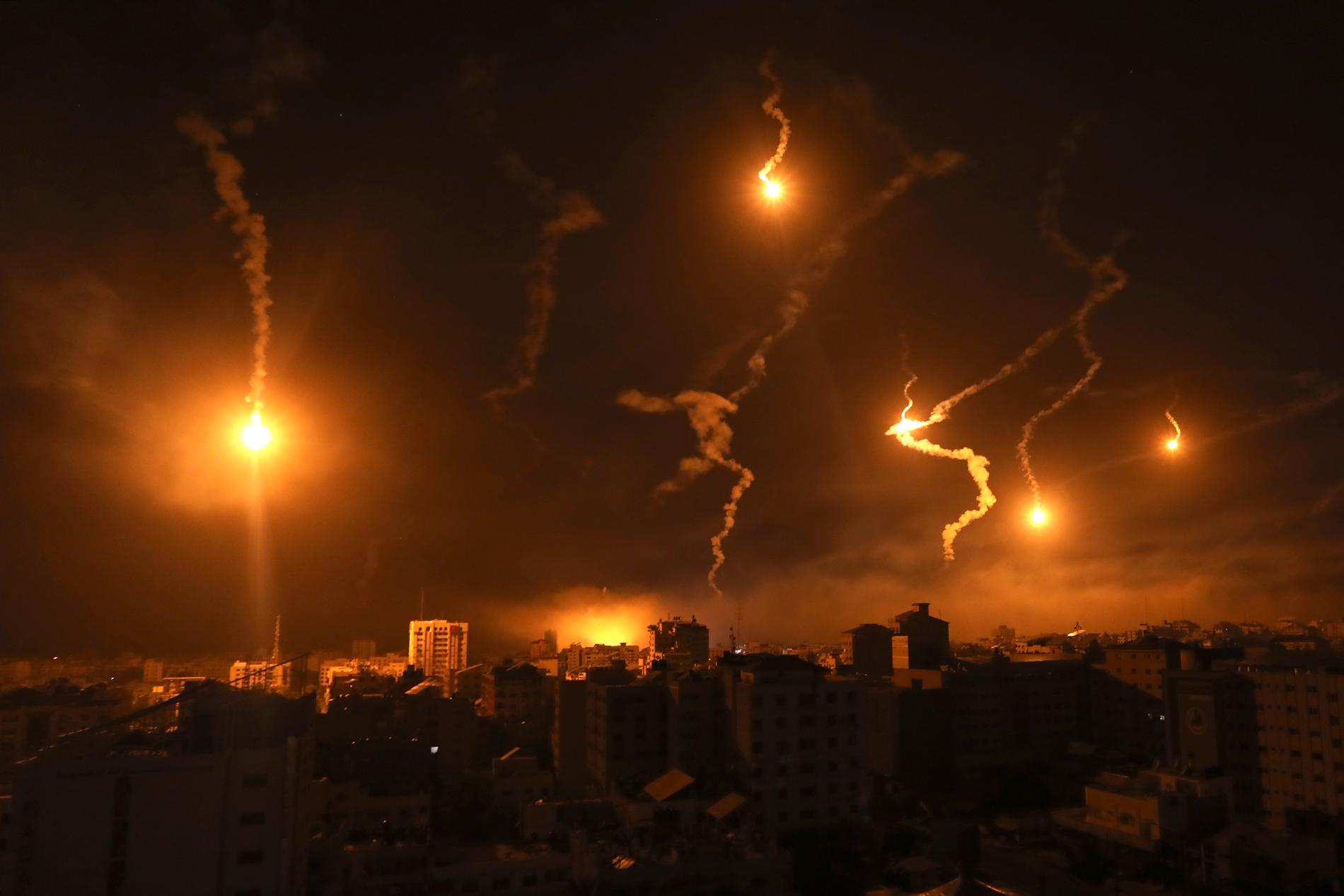 Lysraketer från israeliska styrkor lyser upp natthimlen i Gaza stad.