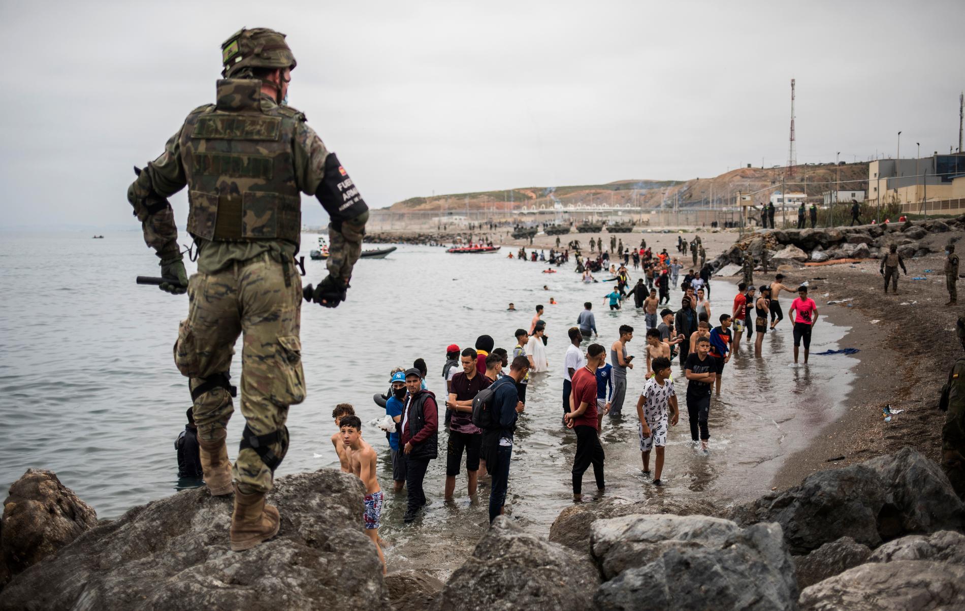 Människor som har simmat eller vadat till Ceuta står i vattnet sedan gränsområdet i den spanska enklaven spärrats av.