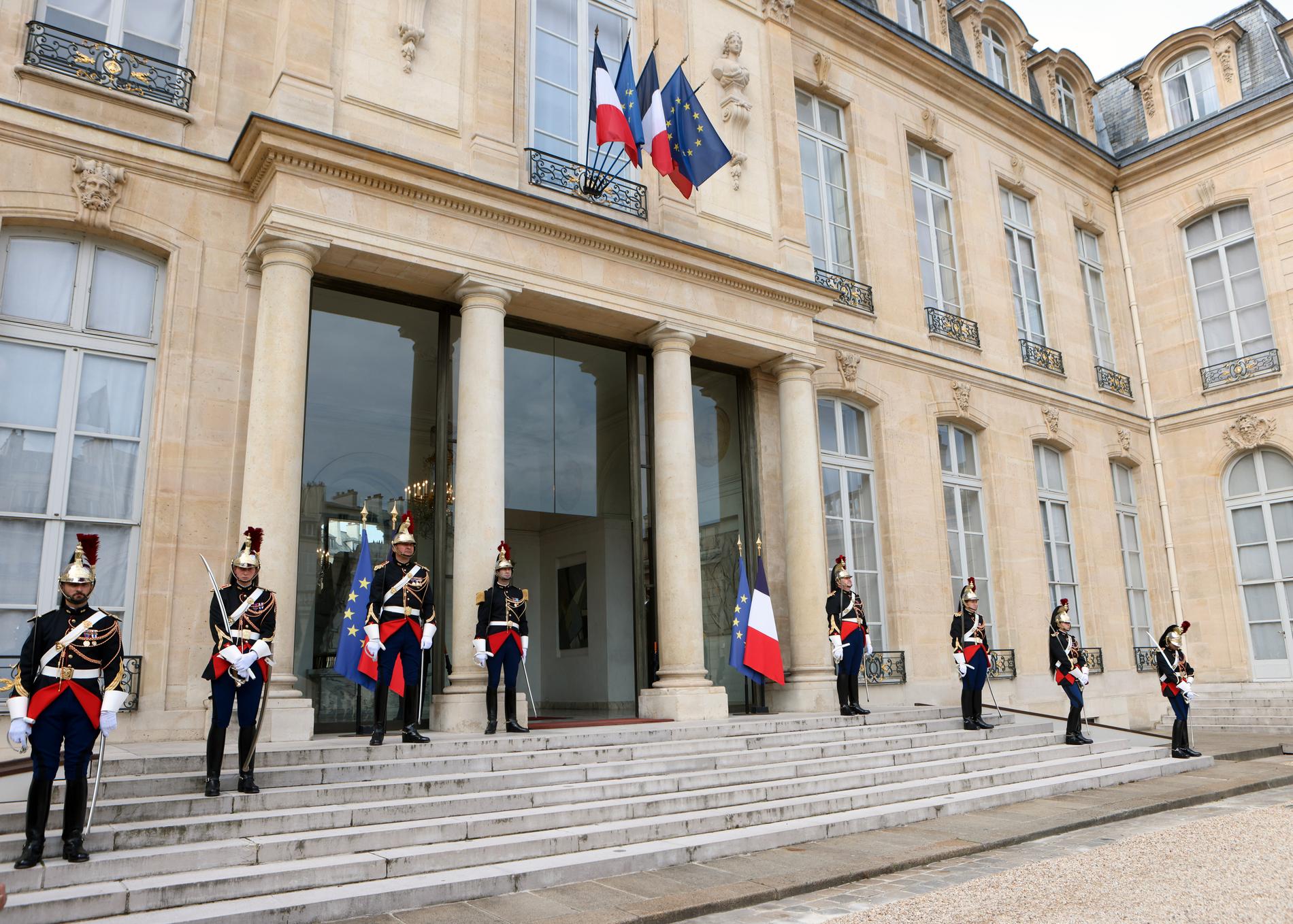 Utanför Elysée-palatsets huvudingång står beväpnade poliser.