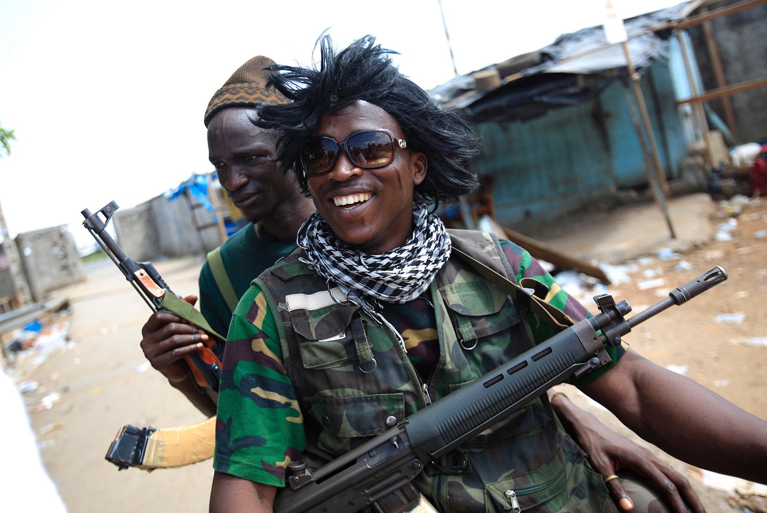 En soldat lojal med Ouattara bär en peruk han hävdar tillhört Simone Gbagbo, efter att rebeller intagit och plundrat paret Gbagbos hus år 2011.
