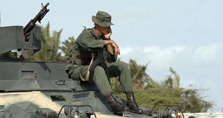 En venezolansk soldat väntar på sitt beväpnade fordon på måndagen, vid en kontrollstation i Las Guardias i Venezuela, cirka 60 kilometer från colombianska gränsen.